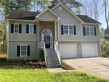 Charming two-story home with a stone entrance, gray siding, black shutters, and a two-car garage at 106 Creek Crossing Ln, Temple, GA 30179