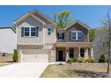 Inviting two-story home with stone and siding exterior, covered entry, and well-manicured front lawn at 1815 Wellston Dr, Lawrenceville, GA 30043