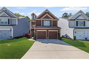 Two-story home with a two-car garage, well-manicured lawn, and inviting curb appeal at 261 Highland Village Ln, Woodstock, GA 30188