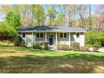 Charming, light grey split-level home with lush, green front yard and mature trees at 133 Cross Gate Dr, Marietta, GA 30068