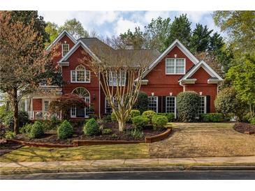 Brick two-story home with manicured landscaping and brick retaining wall at 225 Cotton Field Ct, Alpharetta, GA 30022