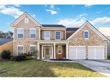 Two-story home with a stone and siding exterior, two-car garage and a well-manicured front lawn at 2319 White Alder Dr, Buford, GA 30519