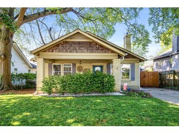 Charming bungalow featuring a well-manicured lawn, inviting front porch, and unique architectural details at 1450 Oglethorpe Sw Ave, Atlanta, GA 30310
