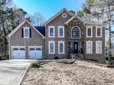 Charming two-story home with stone accents, two-car garage, and manicured front yard at 2311 October Nw Ct, Acworth, GA 30102