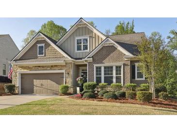 Charming home with a two-car garage, stone accents, and well-maintained landscaping at 5035 Castlegate Ct, Cumming, GA 30040