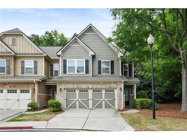 Charming two-story townhome with attached two-car garage, neutral siding and brick accents with mature trees at 1519 Dolcetto Nw Trce # 1, Kennesaw, GA 30152
