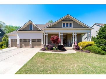 Charming home with a welcoming front porch, three-car garage, and beautifully landscaped front yard at 3137 Perimeter Cir, Buford, GA 30519