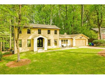 Charming two-story brick home with a well-manicured lawn and mature trees at 2433 Helmsdale Ne Dr, Atlanta, GA 30345