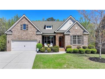 Charming brick home featuring a well-manicured lawn and an attached two-car garage at 5320 Northview Lk, Cumming, GA 30040