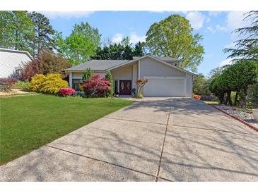 Charming single-Gathering home featuring a well-manicured lawn and inviting curb appeal with a wide driveway at 890 Muirfield Rdg, Marietta, GA 30068