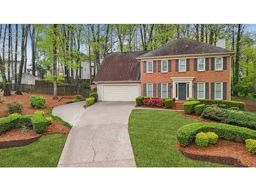 Traditional two-story home featuring a well-manicured lawn and a paved driveway at 989 Vendue Dr, Lawrenceville, GA 30044