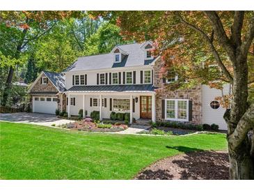 Charming two-story home with a manicured lawn, stone accents, and an attached two-car garage at 4152 Club Ne Dr, Atlanta, GA 30319