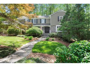 Charming two-story home featuring stone accents, manicured lawn and a stone pathway leading to the front door at 5515 Cross Gate Ct, Sandy Springs, GA 30327