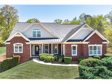 Charming brick home with lush lawn, landscaped shrubbery, and a welcoming front porch at 7804 Gusty Trl, Douglasville, GA 30135