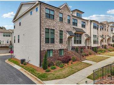Beautiful brick townhome with manicured lawn and landscaping at 245 Fairview Cir, Roswell, GA 30076