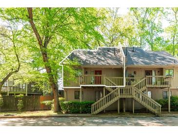 Charming townhouse featuring a wooden deck entrance and lush green surroundings at 2109 Defoors Ferry Nw Rd # D, Atlanta, GA 30318