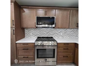 Modern kitchen with stainless steel range and oven, stylish backsplash, and light wood cabinets at 3572 Adkins Nw Rd, Atlanta, GA 30331