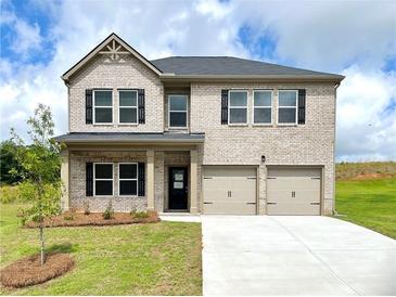 Charming two-story brick home featuring a two-car garage and a neatly landscaped front yard at 678 Egrets Landing #63, Covington, GA 30014