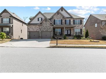 Charming two-story home with brick and stone exterior, well-maintained lawn, and attached two-car garage at 4466 Woodland Bank Blvd, Buford, GA 30518