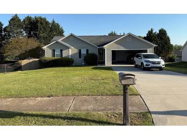 Well maintained single-Gathering home with an attached garage and lush green lawn in a quiet neighborhood at 221 Huntington Dr, Mcdonough, GA 30253