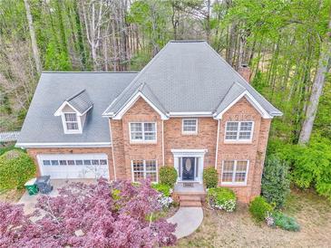 Charming two-story brick home featuring manicured landscaping and an attached two-car garage at 4327 Saint Michaels Dr, Lilburn, GA 30047