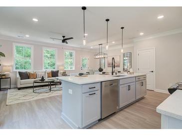 Bright, open-concept kitchen features a large island, modern appliances, and seamless flow into the living area at 116 Winsome Way, Woodstock, GA 30188
