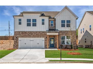 Beautiful two-story home featuring a brick and white siding exterior with a well-manicured front yard and an attached garage at 4202 Adler Cir, Buford, GA 30519