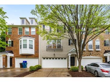 Charming townhome featuring brick and gray painted facade, complemented by an attached two-car garage and tasteful landscaping at 11302 Musette Cir, Alpharetta, GA 30009