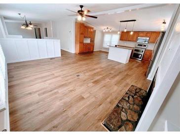 Spacious living room featuring an open floor plan, a stone fireplace, and modern appliances at 3735 Fir Dr, Buford, GA 30518