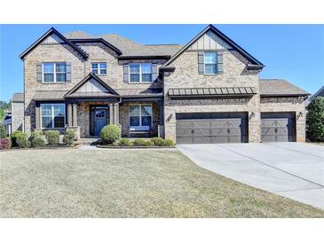 Handsome two story brick home with three car garage and professionally landscaped front yard at 2705 Fox Hunt Way, Cumming, GA 30041