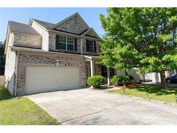 Charming brick two-story home with an attached garage and a well-maintained front yard at 2984 Gayle Manor Ln, Snellville, GA 30078