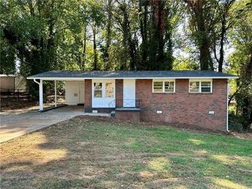 Charming brick home featuring a covered carport and well-manicured front lawn at 398 Windy Hill Se Rd, Marietta, GA 30060