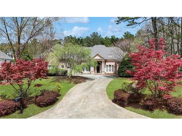 Charming single-story home with well-manicured lawn and a long driveway leading to the front entrance at 2016 Westbourne Way, Johns Creek, GA 30022
