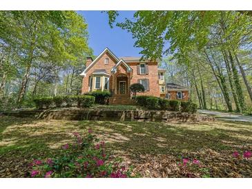 Charming brick two-story home with landscaped front yard on a sunny day at 4650 Riversound Dr, Snellville, GA 30039