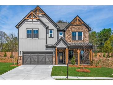 Charming two-story home featuring a mix of brick and gray siding, and inviting covered entryway at 3962 Adler Cir, Buford, GA 30519
