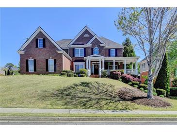 Beautiful two-story brick home with a well-manicured lawn and inviting front porch at 2123 Floral Ridge Dr, Dacula, GA 30019