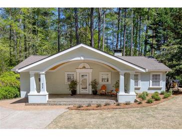 Charming home with inviting front porch, decorative arch, and well-maintained landscaping at 934 Pine Cir, Woodstock, GA 30189