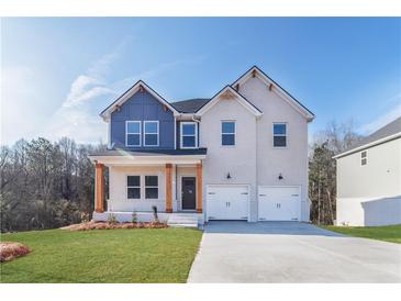 Charming two-story home with a two-car garage, covered porch, and beautifully manicured lawn in front at 288 Overlook Rd, Covington, GA 30014