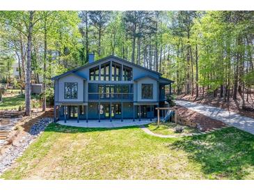 Striking home with large windows, a sprawling lawn, and a wooded backdrop at 1762 Green Rd, Buford, GA 30518
