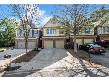 Charming townhome exterior features a two-car garage and inviting curb appeal with nice landscaping at 2840 Smith Ridge Trce, Peachtree Corners, GA 30071