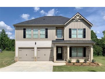 Charming two-story home featuring a two-car garage, black shutters, and manicured lawn at 668 Egrets Landing #64, Covington, GA 30014
