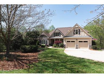 Charming two-story home featuring a stone facade, well-manicured lawn, and a two-car garage at 5095 Hamby Hollow Ln, Cumming, GA 30028