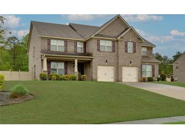 Charming two-story brick home with a well-manicured lawn and a two-car garage at 257 Ironwood Dr, Stockbridge, GA 30281
