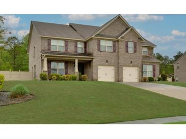 Charming two-story brick home featuring a well-manicured lawn and a two-car garage at 257 Ironwood Dr, Stockbridge, GA 30281