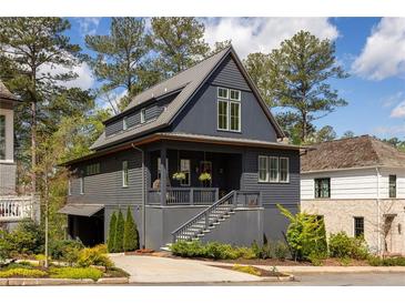 Charming two-story home with a covered porch, gray siding, and metal roof at 1126 Mado Loop, Chattahoochee Hills, GA 30268