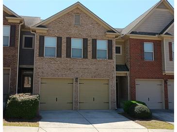 Townhome exterior boasts a brick facade, two-car garage, and well-maintained landscaping at 2162 Oakland Grove Pl, Lawrenceville, GA 30044