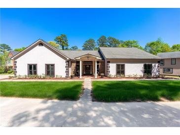 Charming single-story home with white stucco, manicured lawn, and inviting entrance at 2320 Copper Trail Ln, Buford, GA 30519