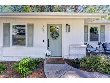 Charming home featuring a light green front door adorned with a wreath and fresh flowers at 705 Stewart Nw Cir, Marietta, GA 30064
