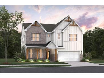 Charming two-story home with brick and white siding, complemented by lush landscaping at 7505 Woolf Way, Cumming, GA 30028