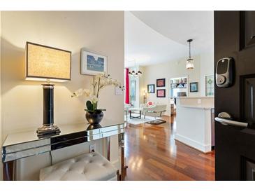 Inviting entryway featuring a mirrored console table, elegant lamp, fresh flowers, and a glimpse into the stylishly decorated living area at 1080 Peachtree Ne St # 3213, Atlanta, GA 30309